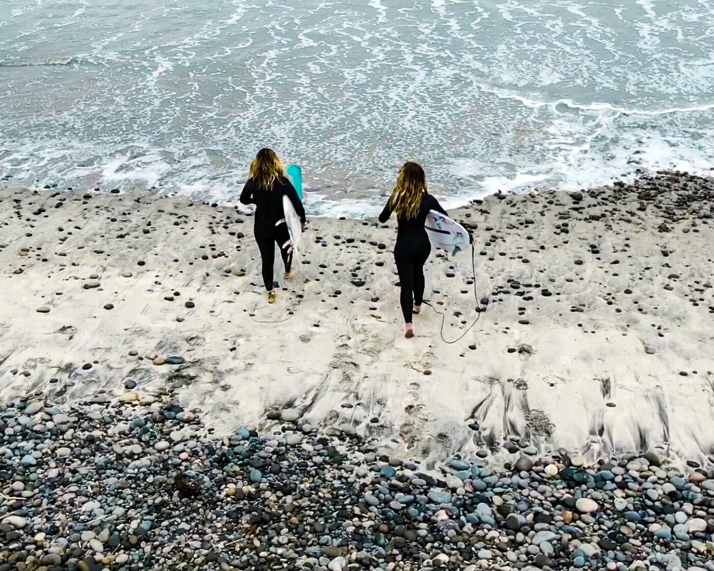 image of two people entering the ocean to go for a surf for surfrider foundation